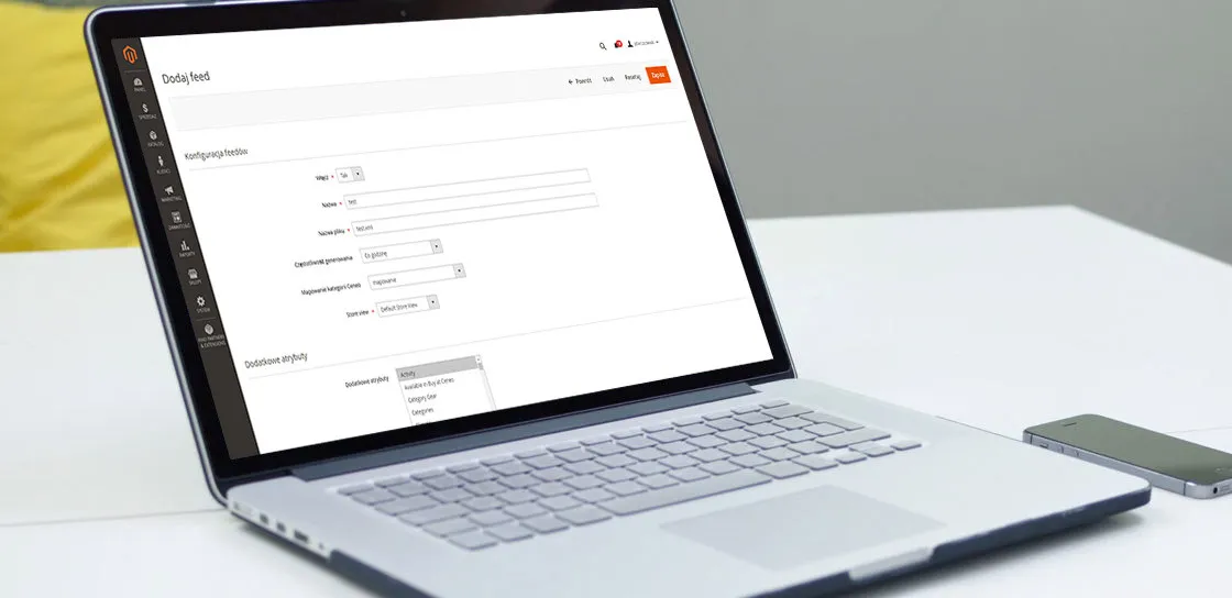 Formularz dodawania feedu w panelu Magento 2 na ekranie laptopa: sekcja Konfiguracja feedu z polami Włącz, Nazwa, Nazwa pliku, Częstotliwość generowania ustawioną na „Co godzinę”, Mapowanie kategorii Ceneo oraz Store view ustawionym na Default Store View, a pod nią sekcja Dodatkowe atrybuty z rozwiniętą listą atrybutów produktu, w której widnieje pozycja „Available in Buy at Ceneo”.